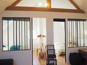 a room with sliding glass doors and a bedroom at Les tilleuls in Persac