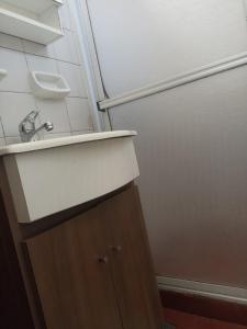 a bathroom with a sink and a refrigerator at Lezca in Concordia +3 photos