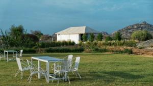 a table and chairs sitting in a field with a table and chairsktop at Innara Hospitality in Mori Bera