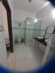 a bathroom with two sinks and a shower and a toilet at Casa charme pipa in Pipa +21 photos