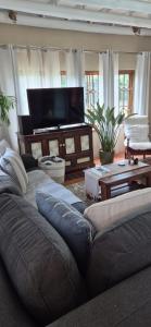 a living room with a couch and a flat screen tv at Udayana House in Hillcrest