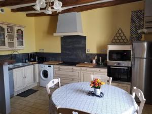a kitchen with a table with flowers on it at La maison de gatienne in Coussay-les-Bois