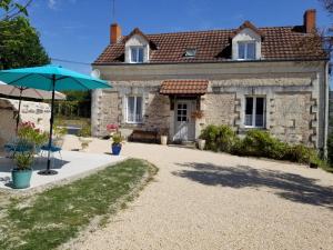 a house with an umbrella in front of it at La maison de gatienne in Coussay-les-Bois