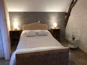 a bedroom with a bed with two pillows on it at La maison de gatienne in Coussay-les-Bois