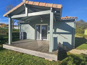 a smallshed with a roof on a wooden deck at Le pic epeiche in Saulgé