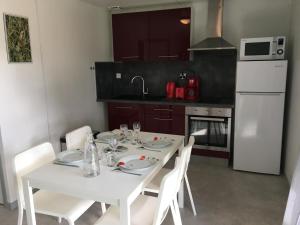 a kitchen with a white table and white appliances at Le pic epeiche in Saulgé