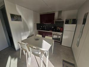 a kitchen with a table and chairs in a kitchen at Le pic epeiche in Saulgé