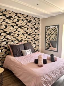 a bedroom with a large bed with a wall of wine bottles at Le chant du jau in Beaumont +32 photos
