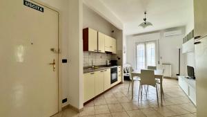 a kitchen and dining room with a table and chairs at Garage Privato Elegante Bilocale in Alassio