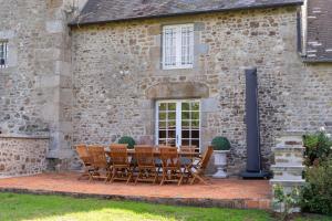 a table and chairs outside of a stone building at Le Grand Mesnil - Collection Idylliq in Pré-en-Pail