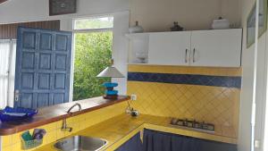 a kitchen with a sink and a counter with a window at Cocooning sur mer Bungalow in Sainte-Anne