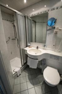 a bathroom with a sink and a toilet and a shower at Hotel Ritter in Tuttlingen