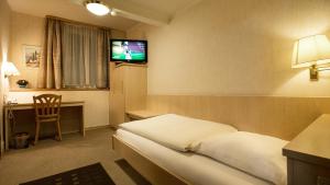 a hotel room with a bed and a flat screen tv at Hotel Ritter in Tuttlingen
