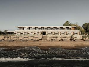 a building with tables and chairs on the beach at Dexamenes Seaside Hotel in Kourouta
