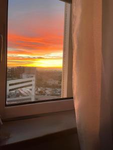 a sunset seen through a window with a curtain at Aleroom25 in Bari