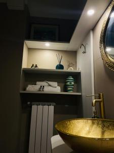 a bathroom with a gold sink and a mirror at Aleroom25 in Bari