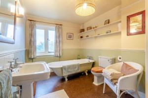 a bathroom with a tub and a sink and a toilet at 4 Bed in Walberswick oc-hfarm2 in Walberswick +24 photos