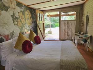 a bedroom with a bed with red pillows on it at Rustique in Graskop