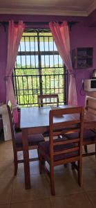 a dining room with a table and chairs and a window at Greenhome apartment in Poli
