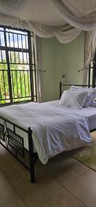 a bedroom with a large bed with white sheets at Greenhome apartment in Poli