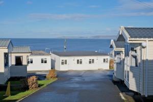 a row of houses with the ocean in the background at Sirocco Caravan in Westward Ho