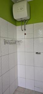 a bathroom with white tiled walls and a tank at Greenhome apartment in Poli +24 photos