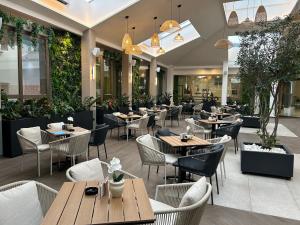 a restaurant with wooden tables and chairs and plants at Hotel Radan Prolom Banja in Prolomska Banja