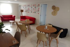 a restaurant with two tables and a red couch at Coloft - Hospedagem e Coworking in Anápolis