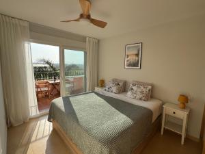 a bedroom with a bed and a view of a patio at Calma Suite Apartment - Mar Menor Golf Resort in Torre-Pacheco