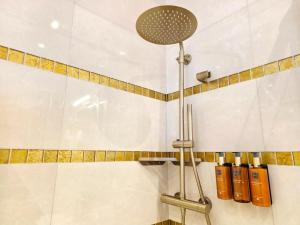 a shower in a bathroom with white tiles at Boutique Hotel am Bodensee in Friedrichshafen