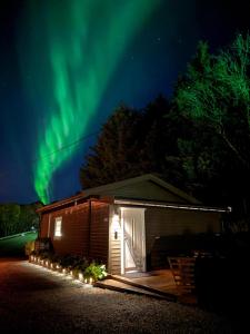 a cabin under the northern lights at night at Sydalen house in Kleppstad