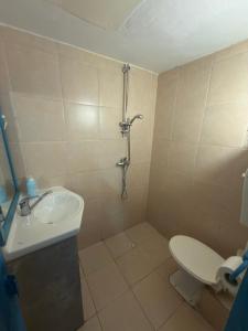 a bathroom with a shower and a toilet and a sink at The Shelter Hostel Eilat in Eilat