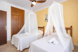 a bedroom with two beds with white sheets at Ca na Moli in Artá +15 photos