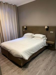 a bedroom with a large bed with white sheets and pillows at Chambre Le Chevalblanc in Ajaccio