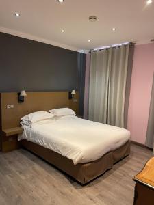 a bedroom with a large bed with white sheets at Chambre Le Chevalblanc in Ajaccio