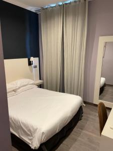 a bedroom with a white bed and a mirror at Chambre Le Chevalblanc in Ajaccio