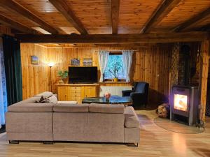 a living room with a couch and a stove at Ferienhaus "BASTEK1" am See mit Kamin & JACUZZI - Domek Letniskowy BASTEK in Pasym