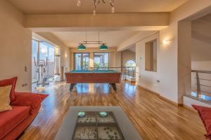 a living room with a pool table in it at Astarte Villas - Istar Villa with Tennis Court in Makhairádhon