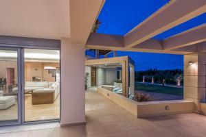 a living room of a house with glass doors at Astarte Villas - Istar Villa with Tennis Court in Makhairádhon +75 photos