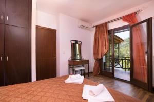 1 dormitorio con 1 cama con toallas en Menir Luxury Apartments, en Prinos