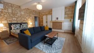 a living room with a blue couch and a table at Hôtes de Saint Emilion in Saint-Émilion +30 photos