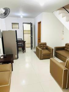a living room with couches and a table and a mirror at Sparrow Transient Townhouse in Davao City