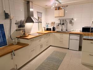 a large kitchen with white cabinets and a stove at Northern Lights Apartment for Independent Stay in Jukkasjärvi