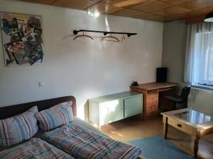 a living room with a couch and a desk at Ferienzimmer Muns in Annaberg-Buchholz