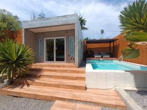 a house with a wooden deck and a swimming pool at Anita dream house in Khao Sok National Park