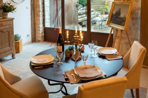 a dining room table with a bottle of wine and chairs at Clos Saint Jacques - Maison d'Hôtes in Meursault +50 photos