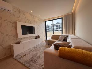 a living room with a couch and a flat screen tv at Apulia Seawind in Apúlia