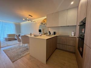 a kitchen and living room with a kitchen island in a room at Apulia Seawind in Apúlia