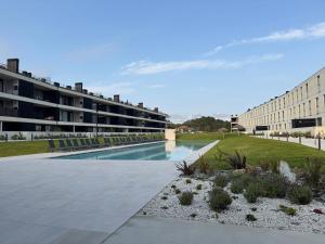 a swimming pool in front of a building at Apulia Seawind in Apúlia