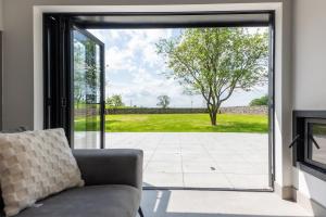 a living room with a couch and a sliding glass door at The Studio at Cherry Tree in Natland
